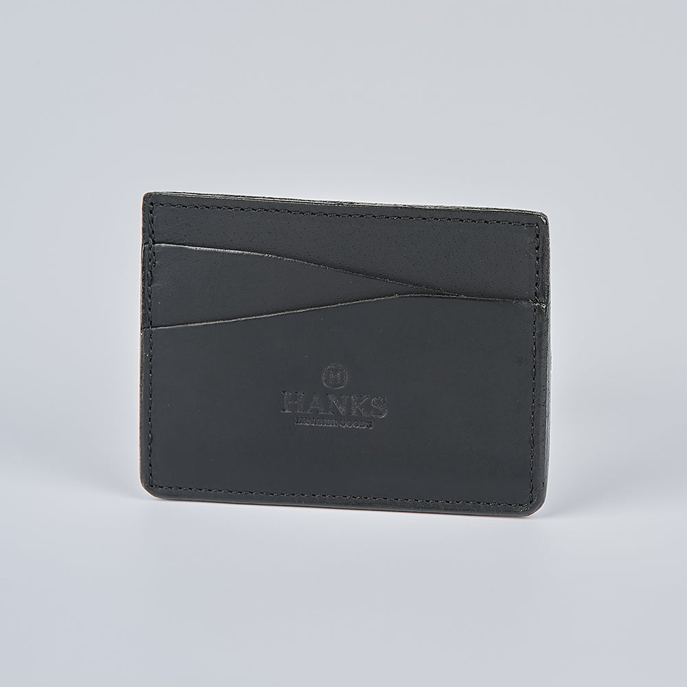 The Cumberland Bison Card Holder by Hanks Belts is a black leather card holder with two card slots on one side and "HANKS LEATHERS" embossed on the front, made in the USA and shown against a plain light gray background.