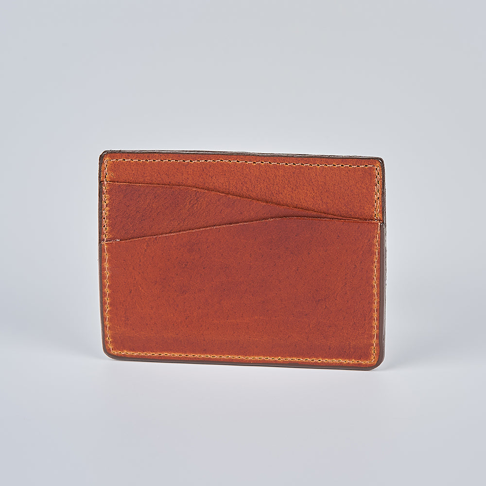 The Hanks Belts Cumberland Bison Card Holder, crafted in the USA from brown bison leather, features two diagonal front card slots and is shown on a plain light gray background.