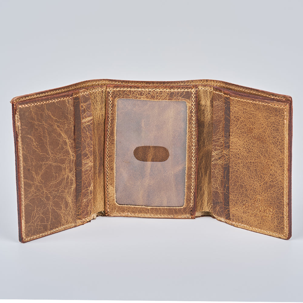 The Hanks Belts Fontana Bison Trifold is an open, brown trifold wallet made of worn bison leather with visible edge stitching, a center transparent ID slot, and handcrafted in the USA, shown on a light gray background.