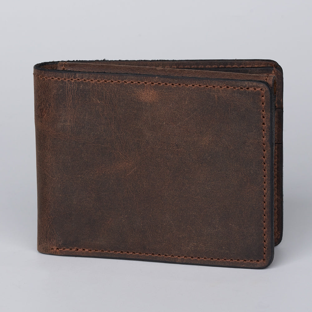 A closed Hanks Belts Huron Premium Bifold with ID Window, made from brown steerhide leather with visible stitching, sits upright on a plain, light background.