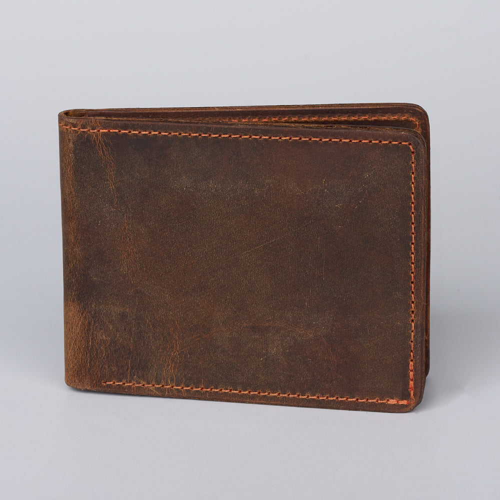 The Hanks Belts Huron Premium Bifold with ID Window, crafted from brown steerhide leather with visible edge stitching, is displayed closed on a plain light gray background.