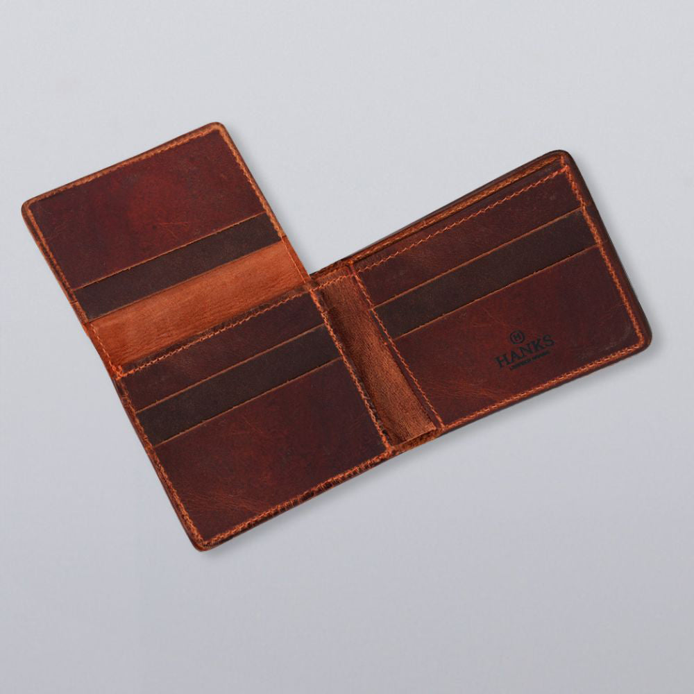 The Hanks Belts Powell Bison Bifold with ID Window Fold Over is an open brown bison leather wallet with multiple card slots and a bill compartment, branded &quot;HANKS&quot; inside on the right, displayed on a light gray background.