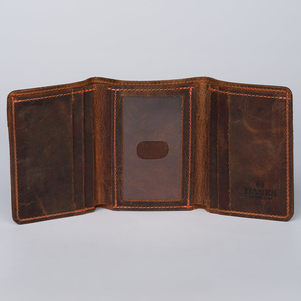 The Saranac Premium Trifold by Hanks Belts is open, displaying multiple compartments with a center clear ID slot, detailed stitching, and &quot;Hanks&quot; printed inside this American-made wallet.