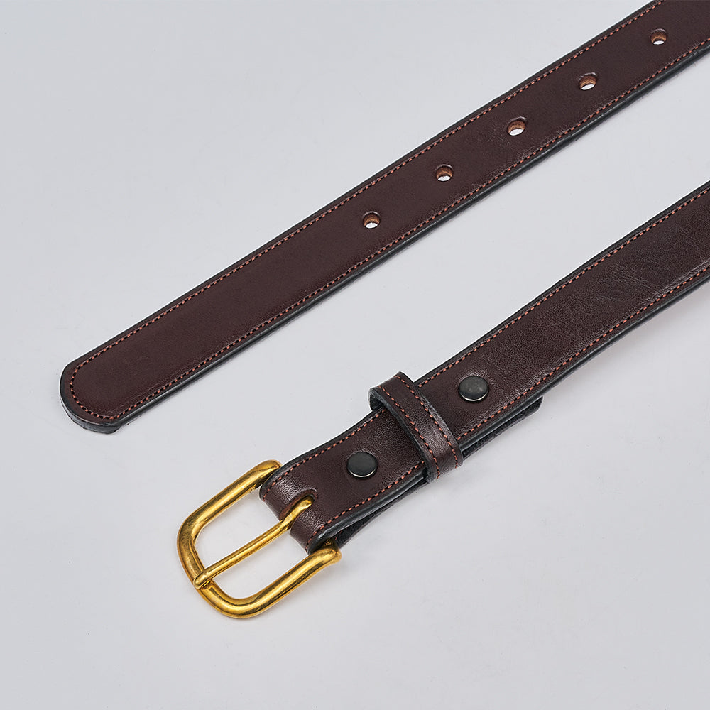 The Addyson - 1&quot; by Hanks Belts, made from English Bridle Full-Grain Leather, is displayed flat on a light gray surface. It features a brass buckle, multiple strap holes, and two black rivets by the buckle.