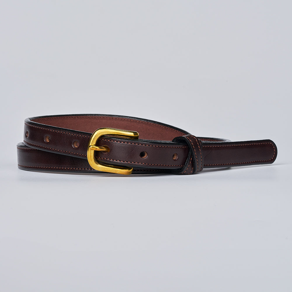 The Dixie by Hanks Belts is a dark brown women&#39;s English Bridle leather belt made in the USA, featuring a gold buckle, edge stitching, and multiple adjustment holes. Shown laid flat on a light gray background.