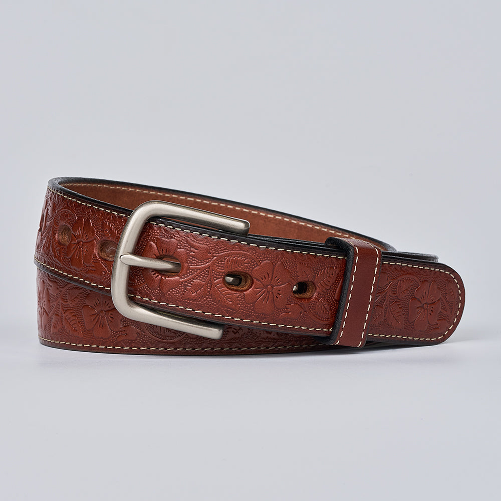 The Floral Embossed by Hanks Belts is a women&#39;s full-grain leather belt with delicate floral embossing, white edge stitching, and a silver buckle, shown coiled neatly on a light gray background.