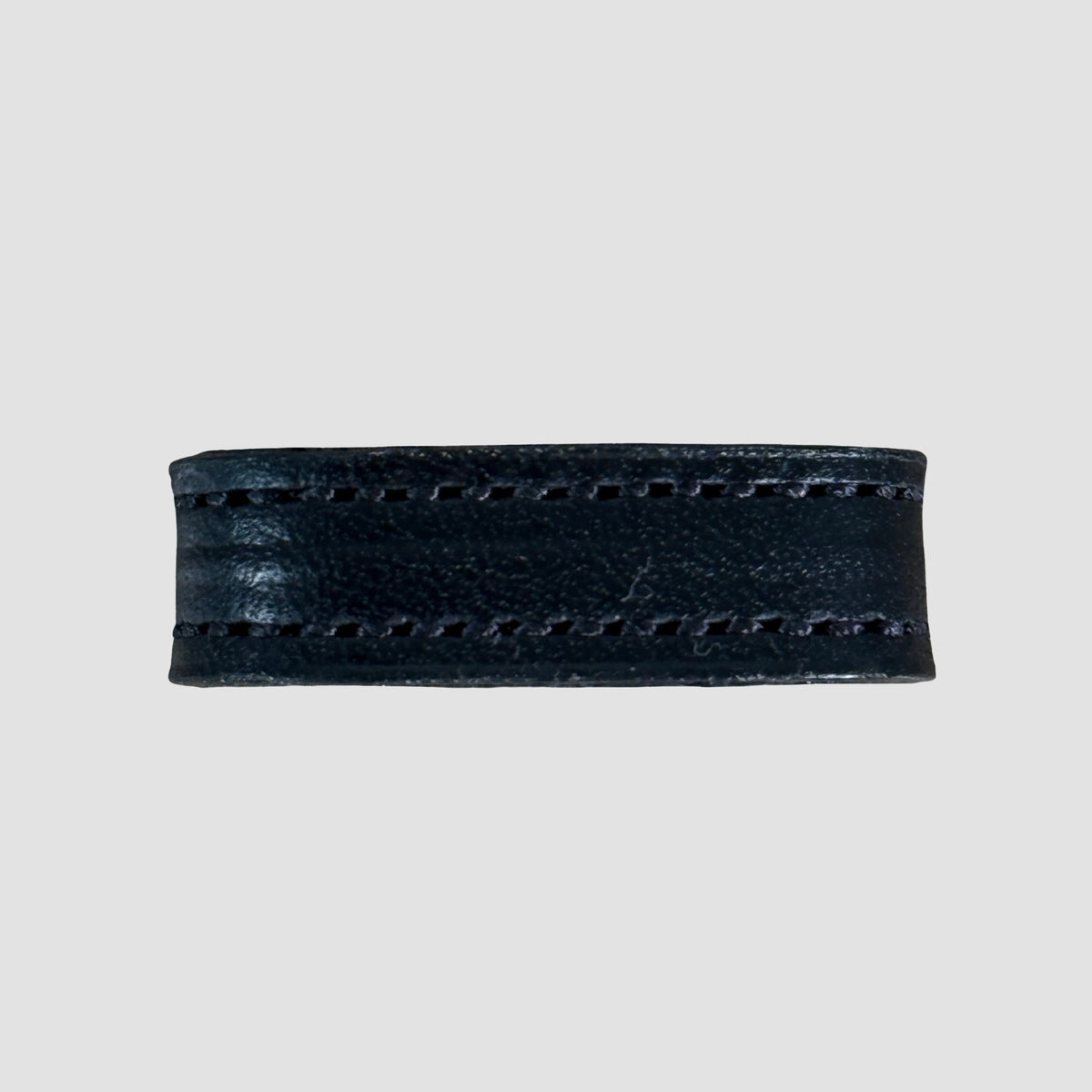 A close-up of the Hanks Belts 1" Stitched #10 Keeper, crafted from black vegetable tanned leather with visible edge stitching, shown against a plain gray background.
