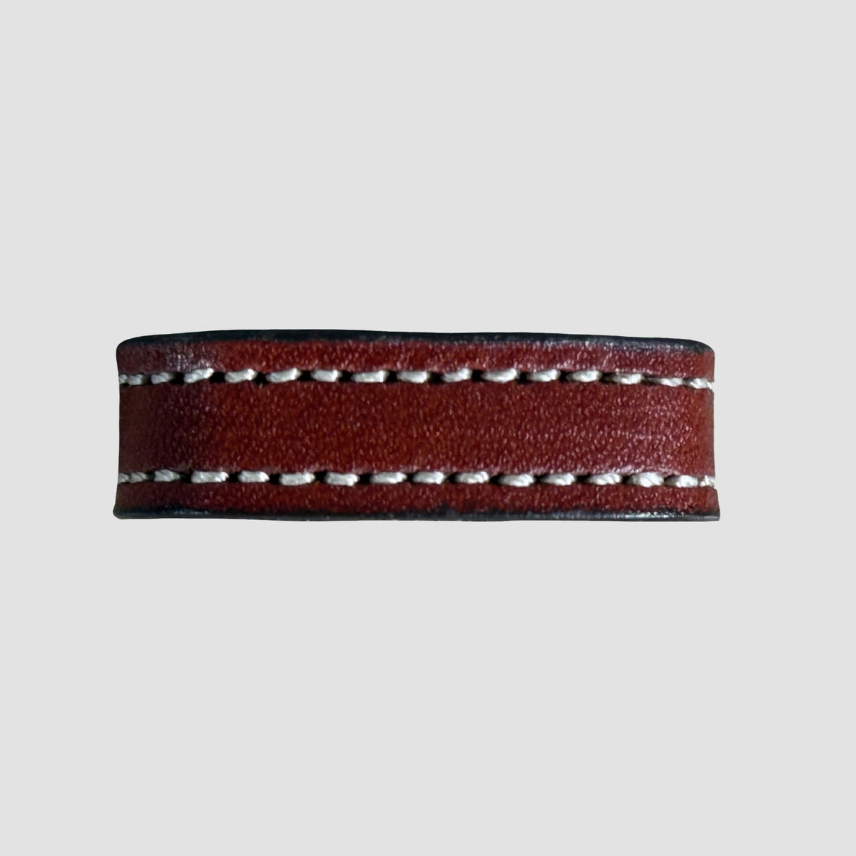 A close-up of the Hanks Belts 1" Stitched #10 Keeper, featuring brown vegetable-tanned leather with double rows of white edge stitching, set against a plain light gray background.