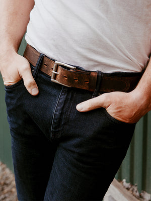 Male model leaning against a green barn wearing Hanks Wyoming 1.5