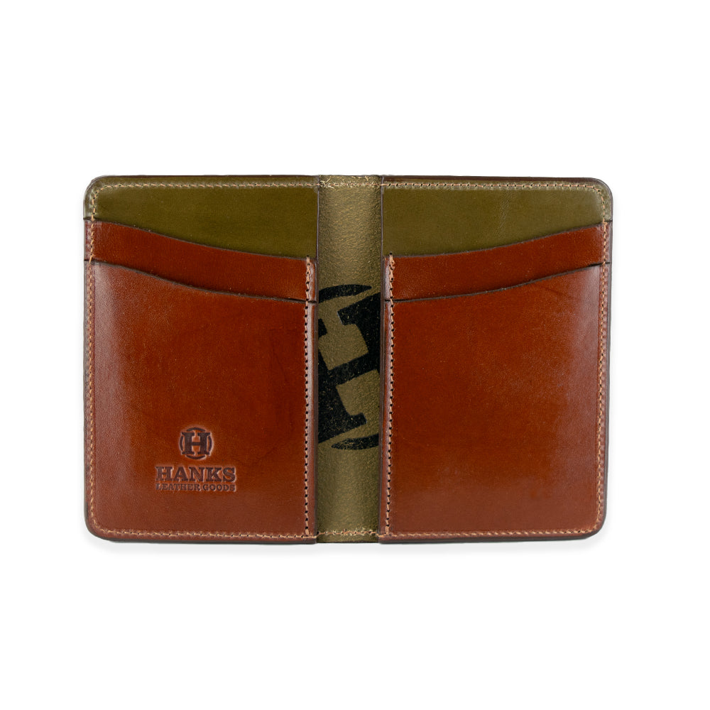 The Superior Front Pocket Bifold by Hanks Belts is a handcrafted wallet with an open design, featuring brown and olive green vegetable-tanned leather. It includes multiple card slots, &quot;Hanks&quot; and a logo embossed on the lower left pocket, and visible edge stitching.