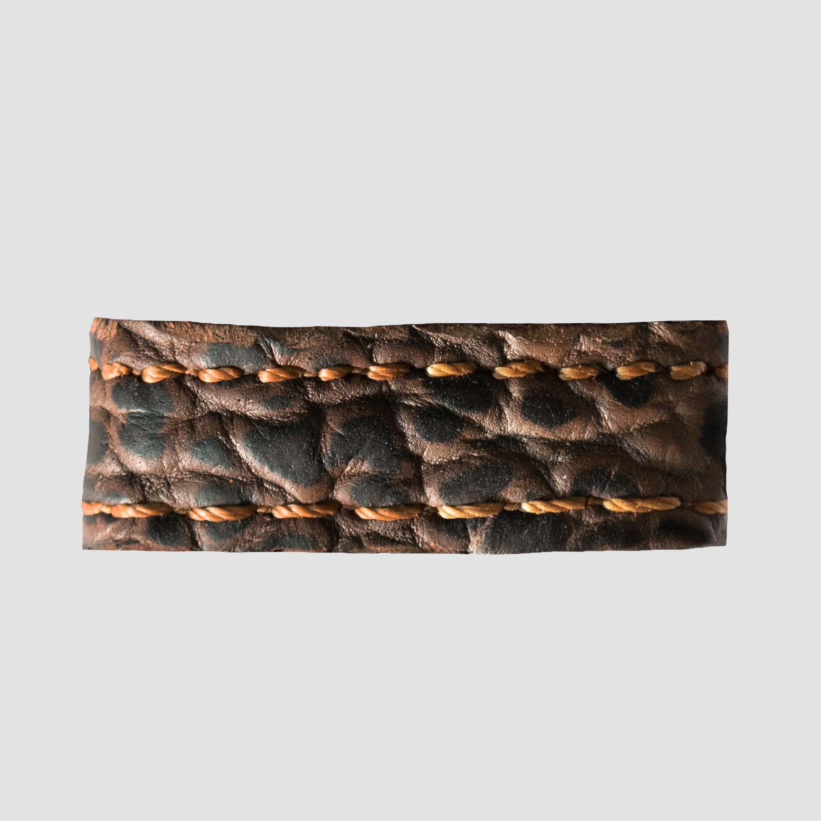 A close-up of the Hanks Belts 1.5" Shrunken Bison #22 Keeper features a textured brown leather strip with orange double stitching, set against a plain light gray background.
