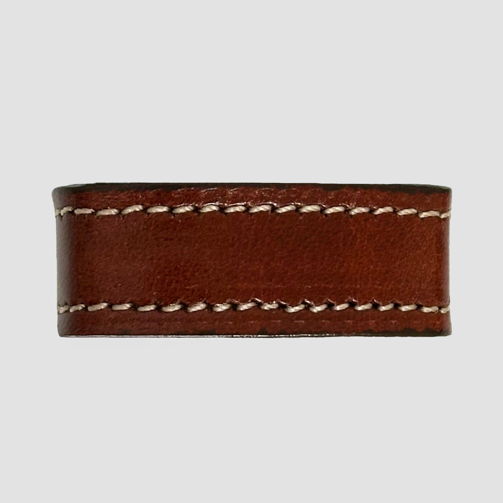 A close-up of the Hanks Belts 1.5" Stitched #10 Keeper in brown vegetable tanned leather with white stitching, shown on a light gray background. Perfect for 1.5" dress belts or as a replacement belt keeper.