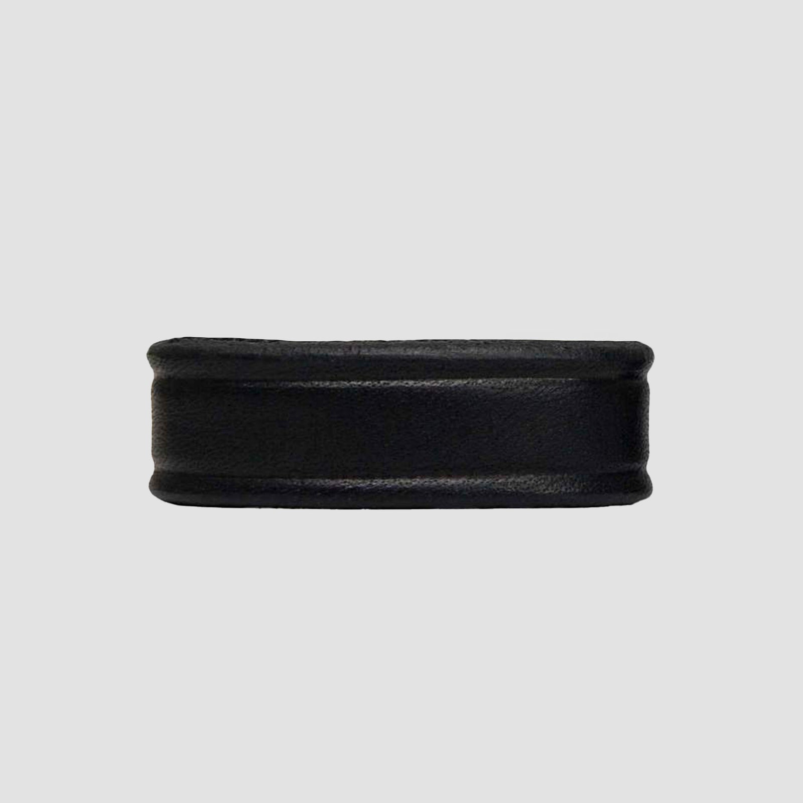 A Hanks Belts 1.25" Smooth #1 Keeper—black, cylindrical rubber ring with a slightly raised edge—resembles belt keepers for 1.25" belts and is set against a plain light gray background.