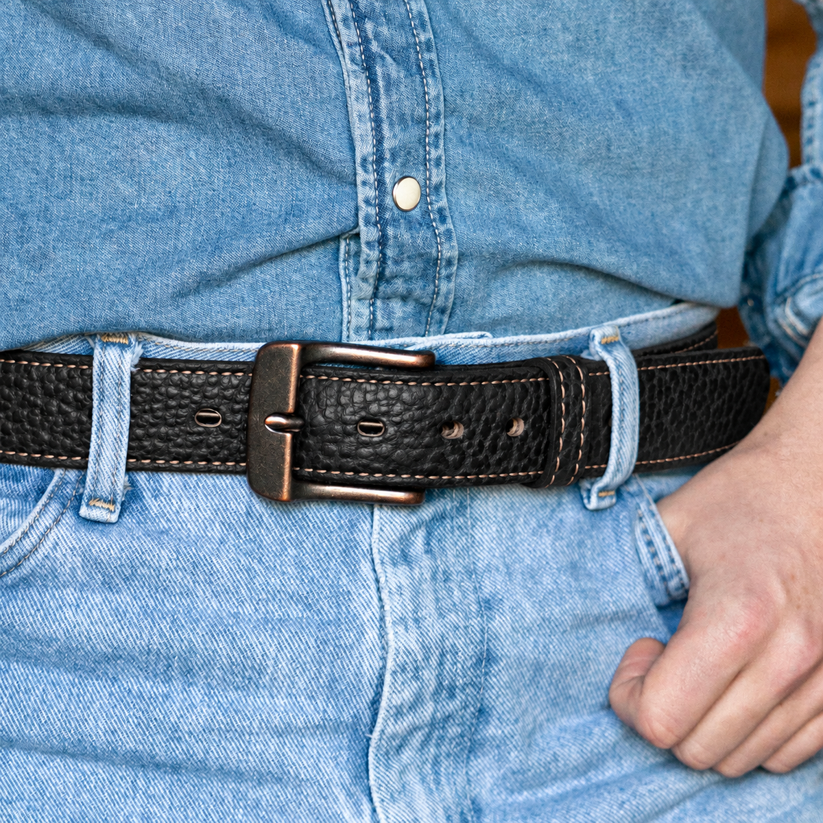 Hanks Belts The Yellowstone: a durable bison leather belt with a copper buckle worn over blue denim jeans.